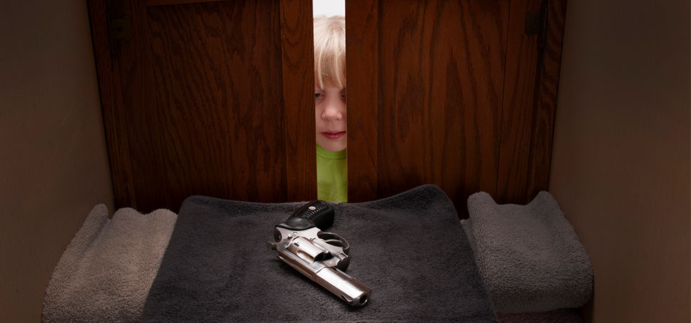 a child peeks inside a cabinet and sees a gun
